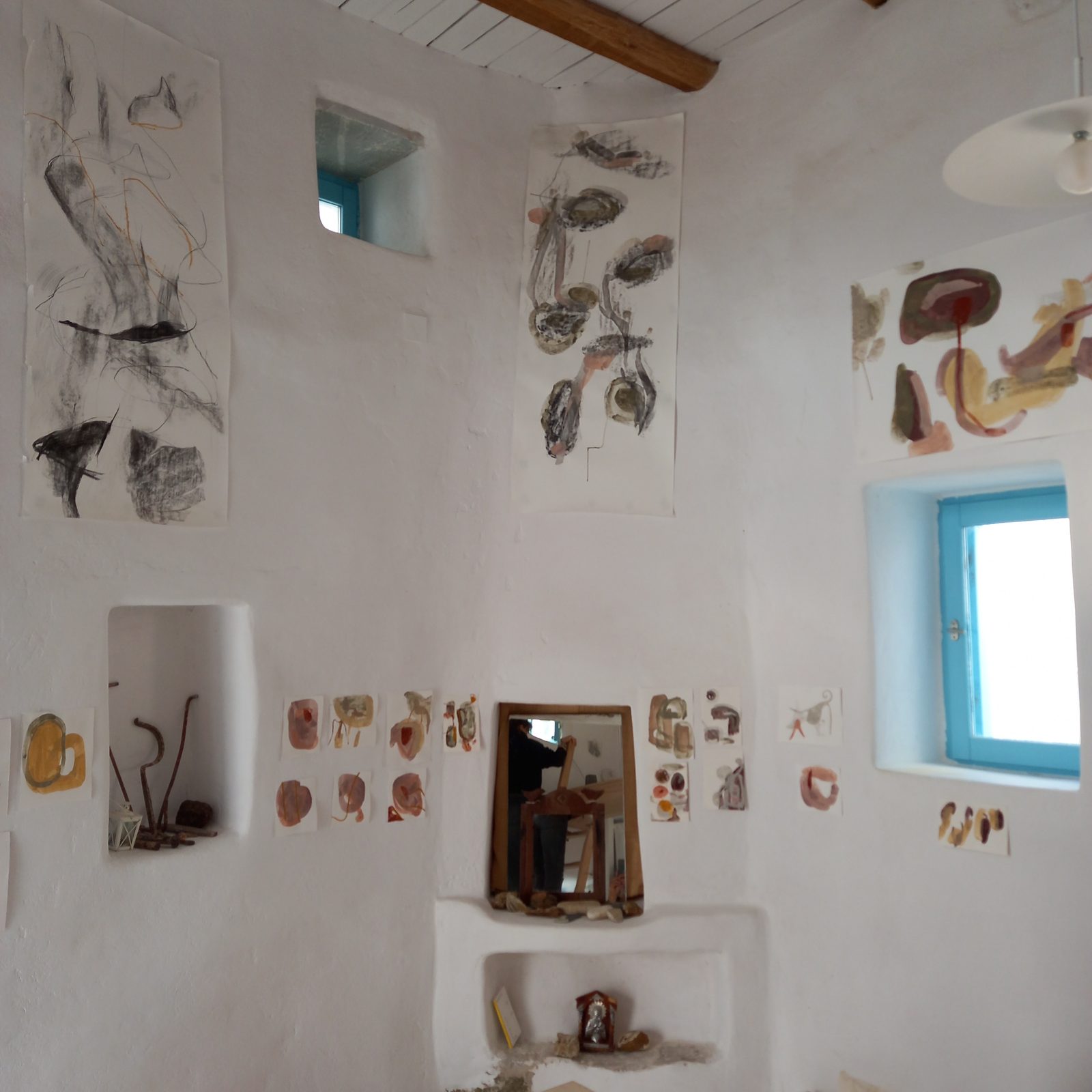 Large charcoal drawings hung high on the studio wall, with rows of pigment drawings beneath